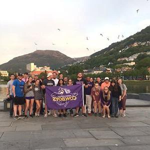 students taking group photo abroad with HSU flag