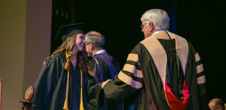 HSU student shaking professor's hand at graduation